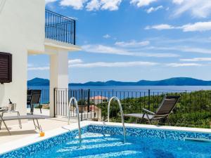 a swimming pool and patio with a view of the water at 3 Bedroom villa with terrace and pool in Zaton Doli