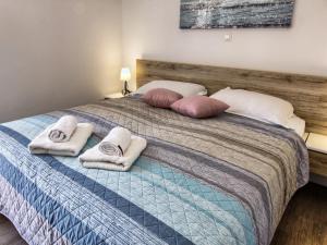 a bed with towels and pillows on top of it at Apartments Victoria - One Bedroom Apartment with Terrace A2 in Pakoštane