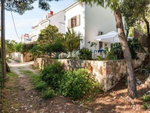 a house with a stone wall and a tree at Apartments Villa Pelegrin - Studio Apartment with Sea View Apartment in Zavala