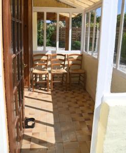 una veranda riparata con sedie e tavolo di Keriven Cottage a Keriven Altre 44 foto