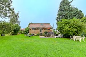 una casa con cortile dotato di tavolo e sedie di Rêves au Chalet - Maisonnette avec jacuzzi a Floyon Altre 10 foto