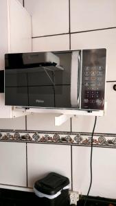 a microwave on a shelf in a kitchen at Apartamento frente a praia Santos in Santos +21 photos