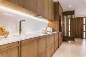 a kitchen with wooden cabinets and a sink at White Stone Villa Orion - Poolside Escape Close to Laganas Beach in Lithakia