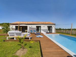 a villa with a swimming pool and a house at Maison pour 6 adultes avec piscine in Notre-Dame-de-Riez