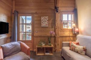 a living room with a couch and two windows at Appartement Samoëns in Samoëns
