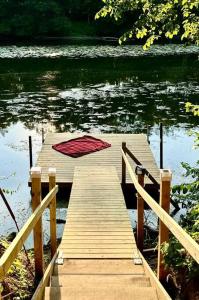 Un muelle de madera con una manta roja sobre el agua. en Family Lake House Waterfront, en Saugerties