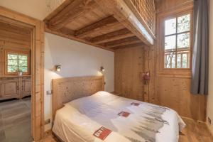 a bedroom with a bed in a room with wooden walls at Appartement Samoëns in Samoëns