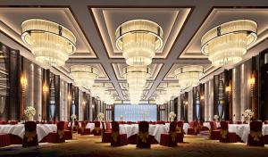 Un salón de banquetes con mesas, sillas y candelabros. en Pullman Shishi Mattison, en Shishi