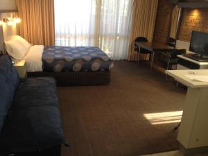 レイクス・エントランスにあるThe Central Hotel Motel Lakes Entranceのベッドと机があるホテルの部屋