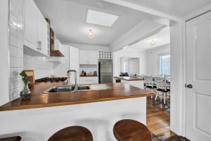 a kitchen with a sink and wooden counter top at Long Island Beach House gateway to Mornington Peninsula#Free parking in Frankston