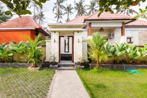 a white house with a red roof at Kubu Kapas Bali in Ubud