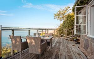 um deque de madeira com uma mesa e cadeiras numa varanda em Apartment Faaborg With Sea View Viii em Fåborg