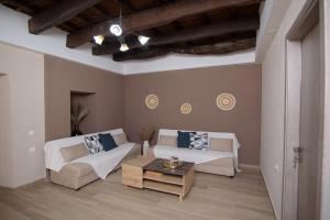 a living room with two couches and a coffee table at Gold Queen Apartment in Áyios Vasílios