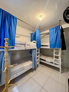 two bunk beds in a room with blue curtains at Nomads Hostel Multicultural & Coworking in Salvador