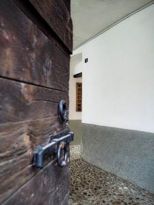 una puerta de madera con un mango metálico en la pared en Casa Armida, en Tirano