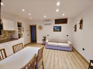 a kitchen and a living room with a table and a couch at Casa Armida in Tirano
