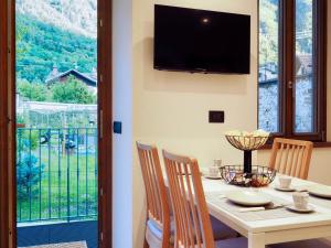 a dining room with a table with chairs and a television at Casa Armida in Tirano