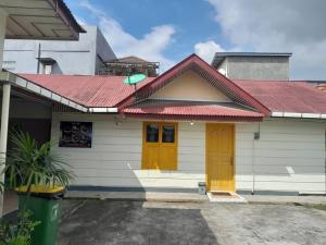 une maison avec des portes jaunes et un toit rouge dans l'établissement PONDOK SITI RAWIYAH Guest House, à Bukittinggi