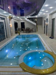 une grande piscine bleue dans un immeuble dans l'établissement Astoria Boutique & SPA, à Samarcande