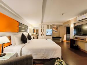 a bedroom with a large white bed and a television at The Key Bangkok Hotel in Bangkok