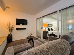 a living room with a couch and a tv at The Key Bangkok Hotel in Bangkok
