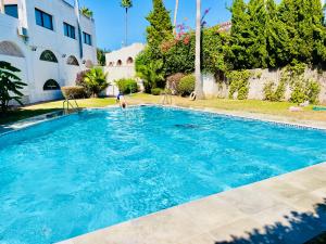 a person is standing in a large blue swimming pool at SuperHosts Suites Estepona in Estepona