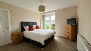 a bedroom with a bed with a television and a dresser at 19 Snowdon Apartment in Stirling
