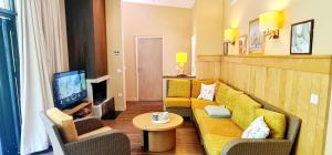 a living room with a couch and a tv at Hakuna Matata domaine des 3 forets-PMR-6 personnes sauna balneo-acces aquamondo non inclus in Hattigny