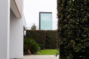 a sign for the night hotel is seen through a hedge at High Street Motel in Echuca