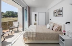 Un dormitorio blanco con una cama y un balcón. en Lovely Home In Vrvari With Sauna, en Poreč