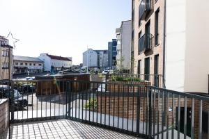 a balcony with a black fence and buildings at Hostit Arctic Apartments By BookLapland in Rovaniemi