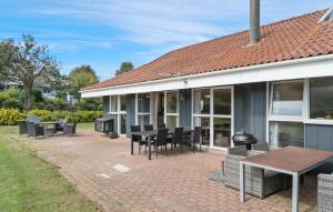 a patio with chairs and tables and a building at Beautiful Home In Hejls With Sauna in Hejls +10 photos
