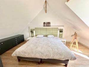 une chambre avec un grand lit dans un grenier dans l'établissement Jusqu'à 24 pers - Jacuzzi - Terrasses - Barbecue - Réunion de famille ou Séminaire, à Verton