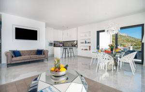a white living room with a table and a couch at 3 Bedroom Lovely Home In Dugi Rat in Dugi Rat