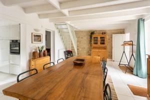a kitchen and dining room with a wooden table and chairs at Gite Chez Grigri pour max 11 pers avec piscine chauffée et jardin in Villebois-Lavalette