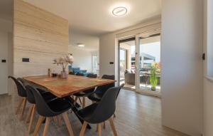 comedor con mesa de madera y sillas negras en 3 Bedroom Awesome Apartment In Kozino, en Kožino