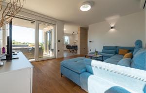 Una sala de estar con un sofá azul y una mesa. en 3 Bedroom Awesome Apartment In Kozino, en Kožino