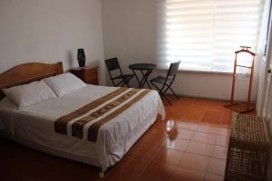 1 dormitorio con 1 cama, mesa y sillas en Hotel Velero Sur, en Iquique