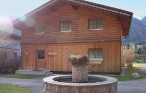 a wooden house with a fountain in front of it at Tolles Feriehaus Montafon in Bartholomäberg +6 photos