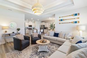 Saint Joe BeachにあるWindmark - Jasmine by the Beachのソファと椅子とテーブルのあるリビングルーム