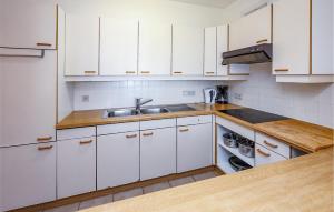 a kitchen with white cabinets and a sink at Residentie Aurore Ref 208 in Ostend