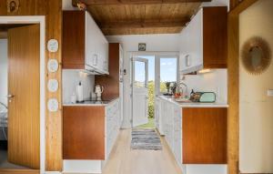 a kitchen with white counters and wooden cabinets at 3 Bedroom Stunning Home In Frørup in Frørup