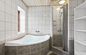 W wyłożonej kafelkami łazience znajduje się wanna. w obiekcie Gorgeous Home In Rudkøbing With Wifi w mieście Rudkøbing