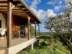 a wooden porch of a house with a bench on it at Vivez cet instant in Le Gosier