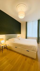 a large white bed in a room with a window at La bulle Stanislas in Nancy
