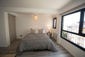 a bedroom with a bed and a large window at Espacio nuevo, tranquilo y céntrico en Bariloche in San Carlos de Bariloche