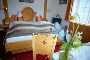 a bedroom with a bed with a wooden bed frame at Hotel Montafon Moments in Sankt Gallenkirch