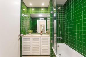 a green tiled bathroom with a sink and a tub at Baixa Chiado LUXURY BEDROOMS in Lisbon +41 photos