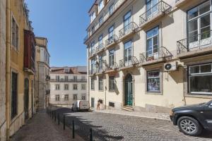 a car parked on a street next to buildings at Baixa Chiado LUXURY BEDROOMS in Lisbon