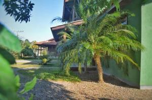 a house with two palm trees in front of it at SunHouse Praia do Rosa in Praia do Rosa